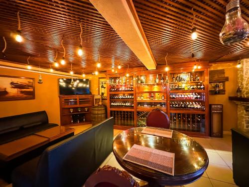 a restaurant with a table and a bar with wine bottles at Le Suisse Spa in Santa Lucía Milpas Altas