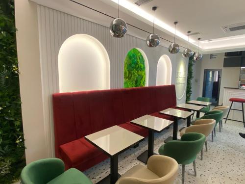 a row of tables in a room with green chairs at Bed & Coffee LUKAS Krusevac in Kruševac