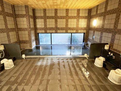 an empty room with two chairs and a large window at Hotel Route-Inn Dai-ni Ashikaga in Ashikaga