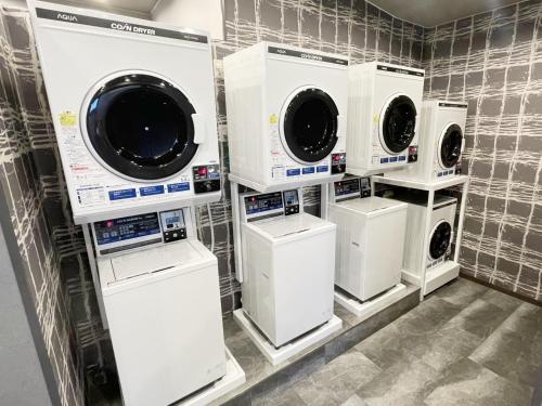 a laundry room with white washing machines and washers at Hotel Route-Inn Dai-ni Ashikaga in Ashikaga