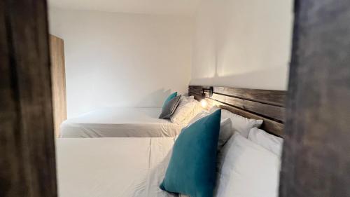 two white beds in a room with blue pillows at HOTEL 9.5 SAN FERNANDO in Cali
