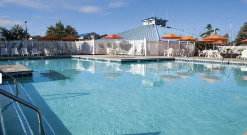 a large blue swimming pool with chairs and umbrellas at Marina Vista Condo III in New Bern