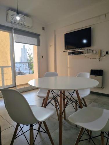 una mesa blanca y sillas en una habitación con TV en Excelente departamento barrio constituyentes, en Santa Fe