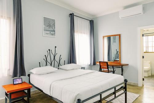 ein Schlafzimmer mit einem Bett, einem Tisch und einem Spiegel in der Unterkunft Sarita Village Homes in Arusha