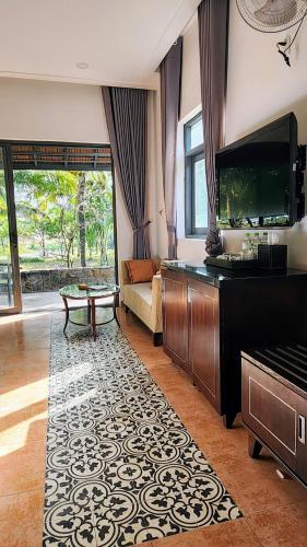 a living room with a fish tank and a piano at ZEN Resort - Villa beach- Garden in Xóm Tram