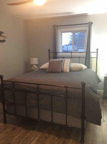 a large bed in a bedroom with a window at Quiet Lake View Firepit, Deck, BBQ, 3 Winery Walk in Essex