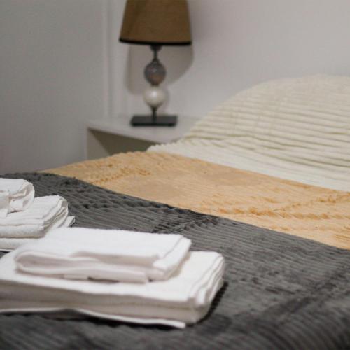 a bed with white towels sitting on top of it at Pueblo Dorado in Malargüe