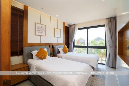 a hotel room with two beds and a window at Happy Stay Resort Wonderland Ho Tram in Xuyên Mộc