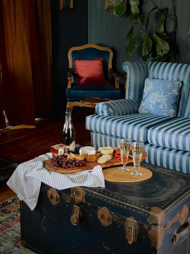 a room with a couch and a table with glasses on a trunk at Linning's House at Twigley Farm in Marburg