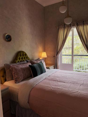 a bedroom with a large bed with a window at Linning's House at Twigley Farm in Marburg