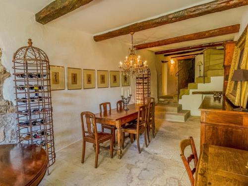 - une salle à manger avec une table, des chaises et des casiers à vin dans l'établissement Maison de charme au coeur du village de Gordes, à Gordes