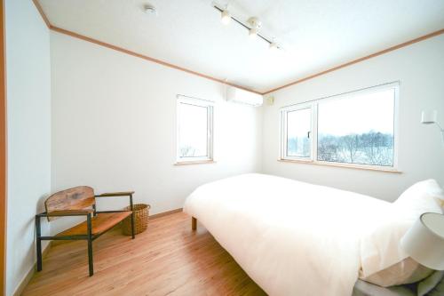 a bedroom with a bed and two windows at Niseko Hulk18 in Niseko