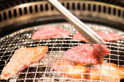 a grill with some meat being being grilled at Hotel Public Jam in Osaka