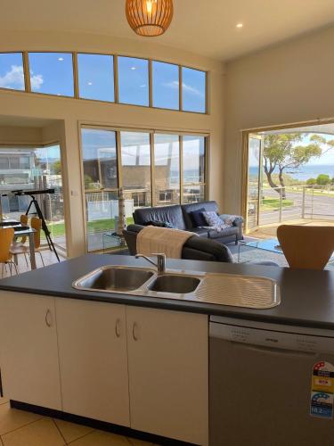 a kitchen with a sink and a living room at Seaview on The Esplanade in Portarlington