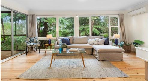 a living room with a couch and a table at "Forest home,Lake view" in Hornsby