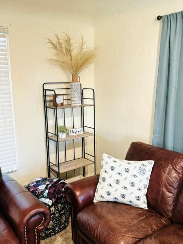 a living room with a leather couch and a shelf at Charming Modernized Farmhouse in Moxee City
