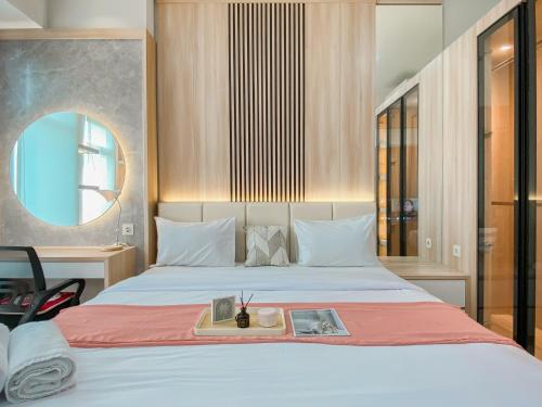 a bedroom with a bed with a tray on it at Big and Comfy Studio at Vasanta Innopark Apartment By Travelio in Cikarang