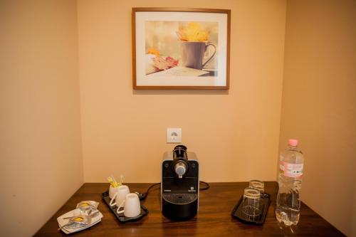a table with a toaster and a picture on the wall at Braun Rooms Deluxe in Sopron