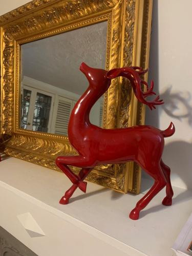 a red statue of a red deer in front of a mirror at Charming Bloor West Retreat in Toronto
