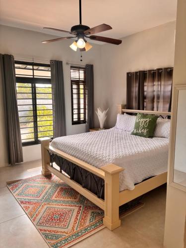 a bedroom with a bed with a ceiling fan at Beachscape At Black River Zermatt in Black River