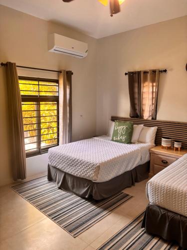 a bedroom with two beds and a window at Beachscape At Black River Zermatt in Black River