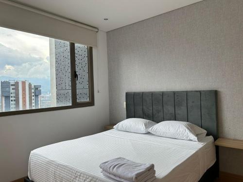 une chambre avec un grand lit avec une fenêtre dans l'établissement Amazing 3 bedroom near Provenza- El Poblado 701, à Medellín