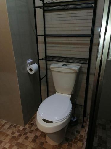a white toilet in a bathroom with a shelf at Apartment near hospitals in Campeche