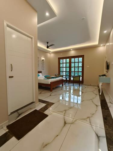 a large room with a bed and a living room at Le French Nest in Puducherry