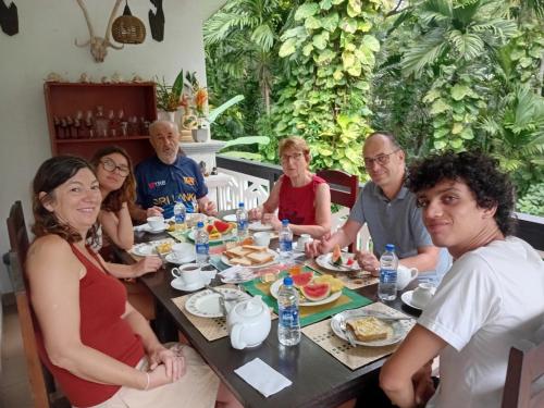 a group of people sitting around a table eating food at Green turf in Galle