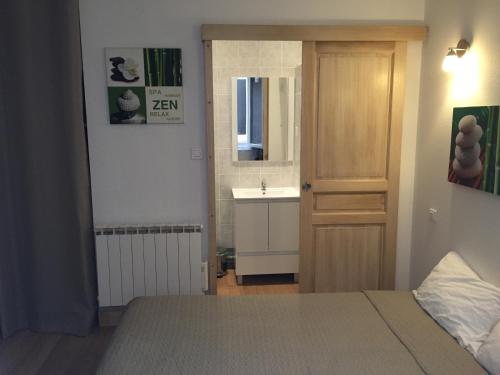 a bathroom with a bed and a sink and a door at Résidence Natura in Ax-les-Thermes