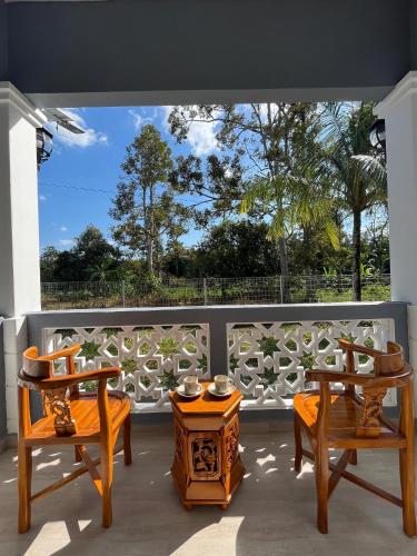 two chairs and a table on a balcony with a view at Homestay Villa D'Manggis in Alor Setar