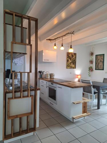 eine Küche und ein Esszimmer mit Tisch und Theke in der Unterkunft Chez Madeline in Le Gosier