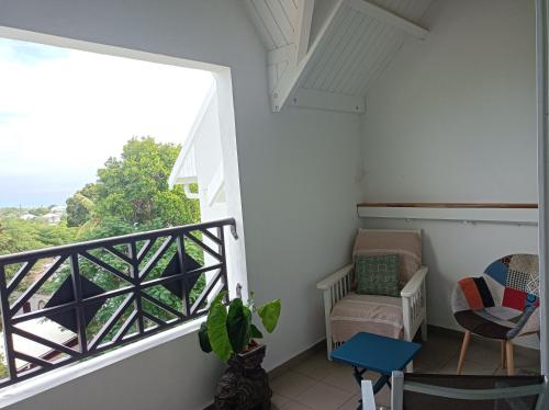 ein Zimmer mit Balkon, mit Tisch und Stuhl in der Unterkunft Chez Madeline in Le Gosier