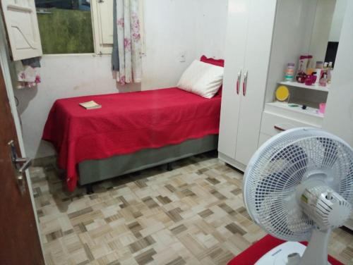 Kleines Zimmer mit einem Bett und einem Ventilator. in der Unterkunft Casa em Milagres in São Miguel dos Milagres
