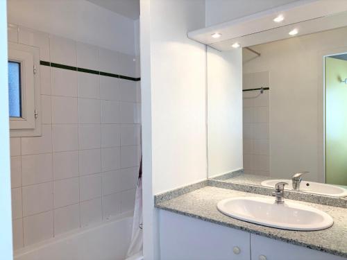 une salle de bain avec un lavabo et un miroir dans l'établissement Maison de vacances 2 chambres avec jardin, terrasse ensoleillée et parking, au calme et boisée - FR-1-323-541, à Saint-Jean-de-Monts