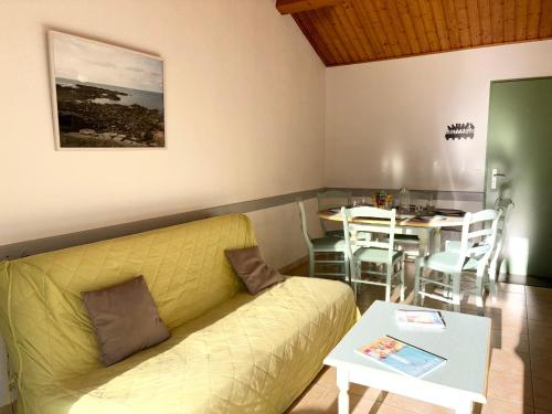 un salon avec un canapé et une table dans l'établissement Maison de vacances 2 chambres avec jardin, terrasse ensoleillée et parking, au calme et boisée - FR-1-323-541, à Saint-Jean-de-Monts
