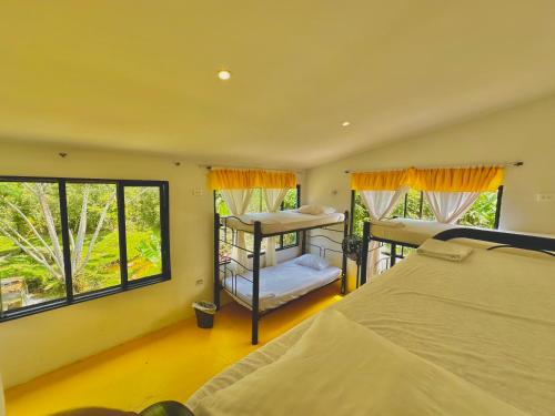 a bedroom with two bunk beds and two windows at Amalaya Hostel in Restrepo