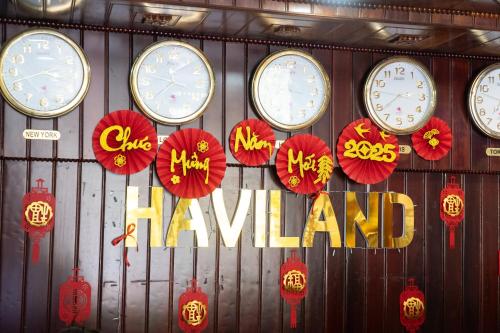 a bunch of clocks on a wall with umbrellas at SeaColor Beachstay Danang Hotel by Haviland in Da Nang
