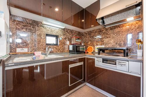 a kitchen with wooden cabinets and stainless steel appliances at Ikebukuro house with 3BR Shinjuku 5min in Tokyo