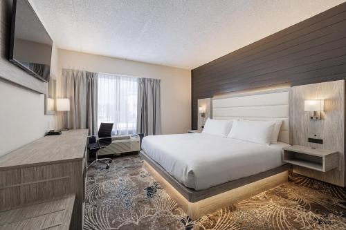 a hotel room with a bed and a desk at Oakfield Hotel & Suites, an Ascend Collection Hotel in Rochester