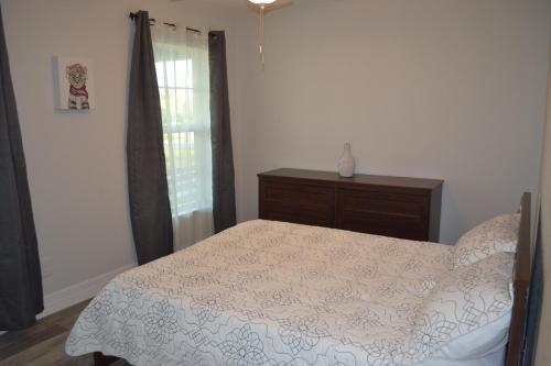 a bedroom with a bed and a dresser and a window at DreamHome in Rotonda West