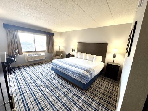 a hotel room with a bed and a window at AmericInn by Wyndham Ames in Ames