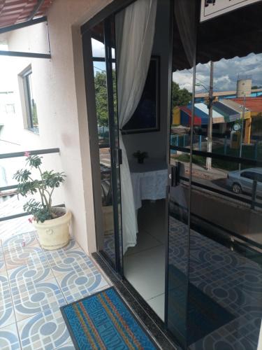 an open door to a balcony with a potted plant at Vip Girassol in Cuiabá