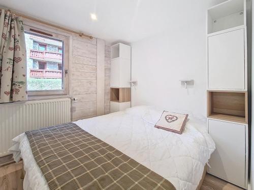 une chambre avec un lit et une fenêtre dans l'établissement Appartement PMR · Proche pistes · Balcon · Piscine, Hammam, Sauna · 4 pers - FR-1-344-793, aux Menuires
