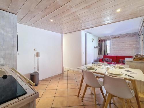 une cuisine et une salle à manger avec une table et des chaises dans l'établissement Appartement PMR · Proche pistes · Balcon · Piscine, Hammam, Sauna · 4 pers - FR-1-344-793, aux Menuires