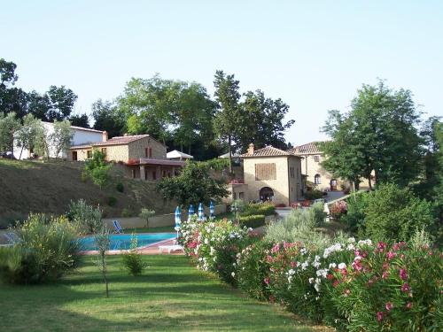 a garden with flowers and a swimming pool at Agriturismo Casale Giulia in Volterra