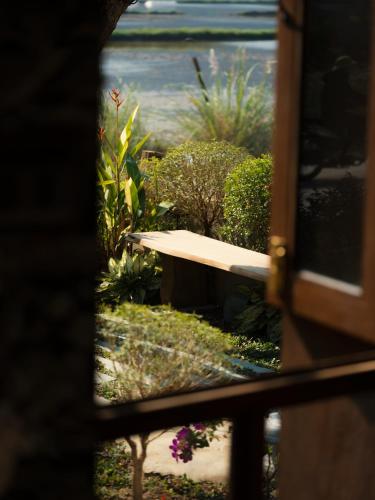 a bench in a garden with plants and flowers at Ailee Villa&Hotel TamCoc in Ninh Binh