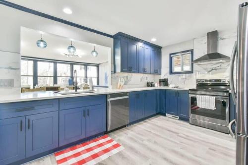 a blue and white kitchen with blue cabinets at Lake Lanier, Lakefront, Boating, Hot Tube, Games, Luxury, Family, Friends, Hiking, Fishing and Birdwatching in Flowery Branch