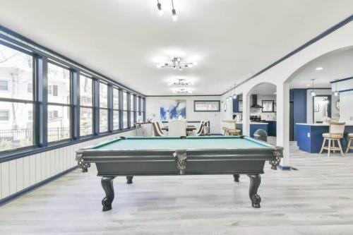 a pool table in a large room with windows at Lake Lanier, Lakefront, Boating, Hot Tube, Games, Luxury, Family, Friends, Hiking, Fishing and Birdwatching in Flowery Branch