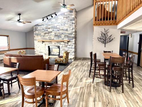 a restaurant with tables and chairs and a fireplace at AmericInn by Wyndham Ames in Ames